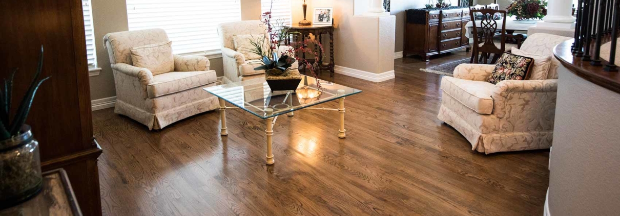 Sala con piso laminado de Villa Pisos